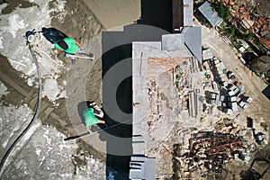 Construction workers screeding floor in new building.