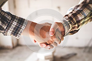 Construction workers shaking hands with project engineers