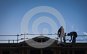 Construction Workers Silhouette on Roof