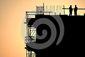 Construction workers silhouettes at sunset