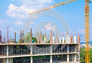 Construction workers site and building of housing at laborer work outdoor which has tower crane blue sky background with copy sp