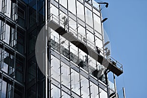 Construction workers on a suspended platform on a skyscraper photo