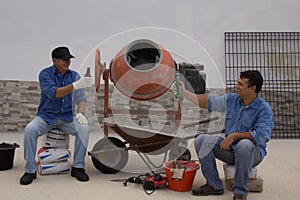 Construction workers taking a break while drinking a beer. Men at work on a construction site