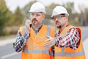 Construction workers talking to walkie-talkie