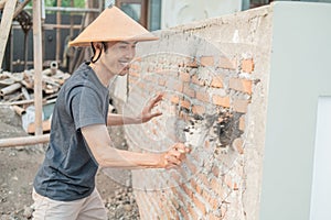 Construction workers use scoops to attach cement to the bricks