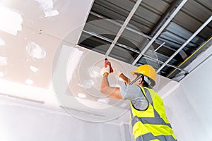 Construction workers using an electric drill are install the ceiling house at construction site, Ceiling installation ideas