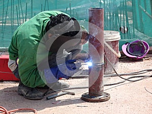 Construction workers welding pipes at the construction site.