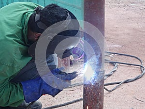 Construction workers welding pipes at the construction site.