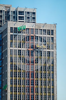 Construction workers are working on the exterior wall under the scorching sun