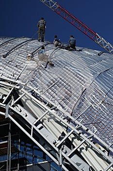 Construction workers working on the roof of a building tied with