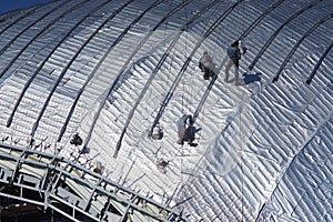 Construction workers working on the roof of a building tied with