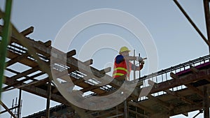 Construction workers working on scaffolding work at risky heights. Steel binding wire strengthens the structure before the columns