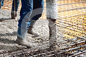 Construction works pouring concrete, directing the pump tube pipe