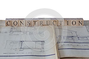 Construction written on wooden blocks on house extension building plans blueprints