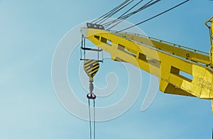 construction yellow crane jib against blue sky