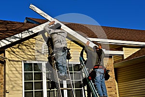 Constructions workers replacing facia on a house
