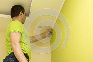 Constructor installs plastic molding to ceiling and wall