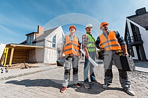 Constructors in helmets holding toolboxes