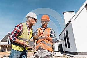 Constructors in helmets standing near houses