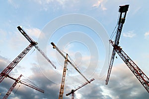 Construstion site with tower cranes against blue sky
