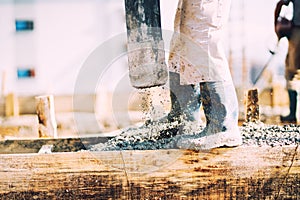 Constuction details - worker laying cement or concrete with automatic pump photo