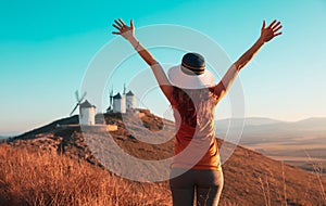 Consuegra Windmills and happy woman arms raised admiring panoramic view- Spain