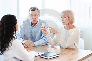 Mature couple asking their doctor about contraindication