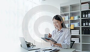 Consultant, advisor, Asian business woman working on the tablet computer work financial and marketing business plan to