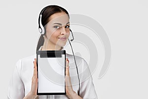 Consultant of call center in headphones holding clipboard