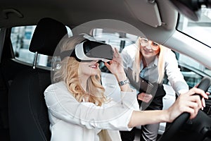 Consultant dealer center demonstrates to the customer the new features of the car in 3d glasses