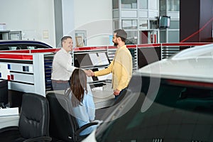 Consultant greets a client in office area of car dealership