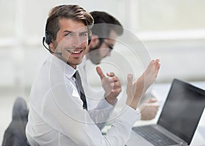 Consultant in headphones sitting at his Desk.