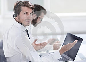 Consultant in headphones sitting at his Desk.