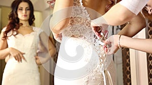 The consultant helps the young woman try a wedding dress. Girl happy to selected wedding dress. young bride makes selfie