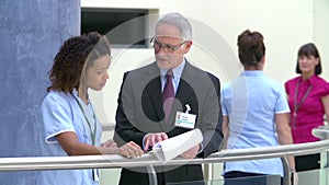 Consultant Meeting With Nurse In Hospital Reception