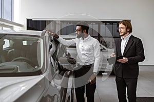 Consultant provides all information about new car using clipboard to male client