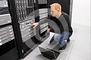 It consultant work with laptop in datacenter