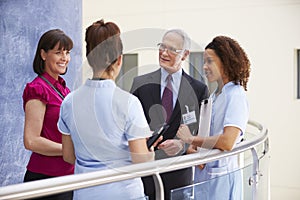 Consultants Meeting With Nurses Using Digital Tablet