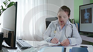 Consultation online, female doctor communicates with sick patient via video communication and writes diagnosis in