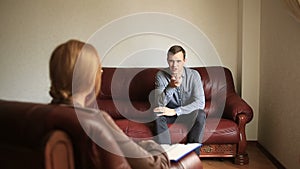 Consultation of a psychologist, a female therapist is consulting a patient with a man with an anxiety disorder