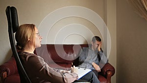 Consultation of a psychologist, a female therapist is consulting a patient with a man with an anxiety disorder