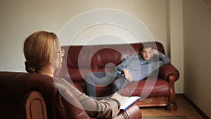 Consultation of a psychologist, a female therapist is consulting a patient with a man with an anxiety disorder