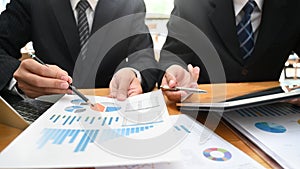 Consulting business with two man analysis finance data with device and paper document