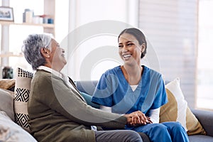 Consulting, caregiver and elderly woman laughing on sofa and holding hands in home living room. Support or healthcare