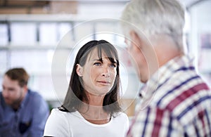 Consulting each other on a project. a mature female business professional talking to a colleague in the office.