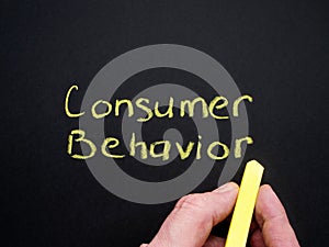 Consumer behavior inscription and hand with chalk.