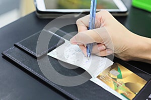 Consumer hand signing on a sale transaction receipt with credit