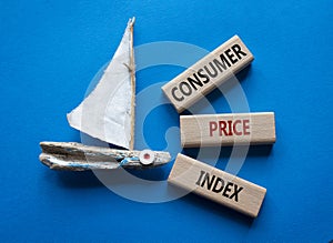 Consumer Price Index symbol. Concept words Consumer Price Index on wooden blocks. Beautiful blue background with boat. Business