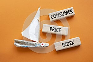 Consumer Price Index symbol. Concept words Consumer Price Index on wooden blocks. Beautiful orange background with boat. Business