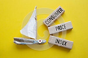 Consumer Price Index symbol. Concept words Consumer Price Index on wooden blocks. Beautiful yellow background with boat. Business